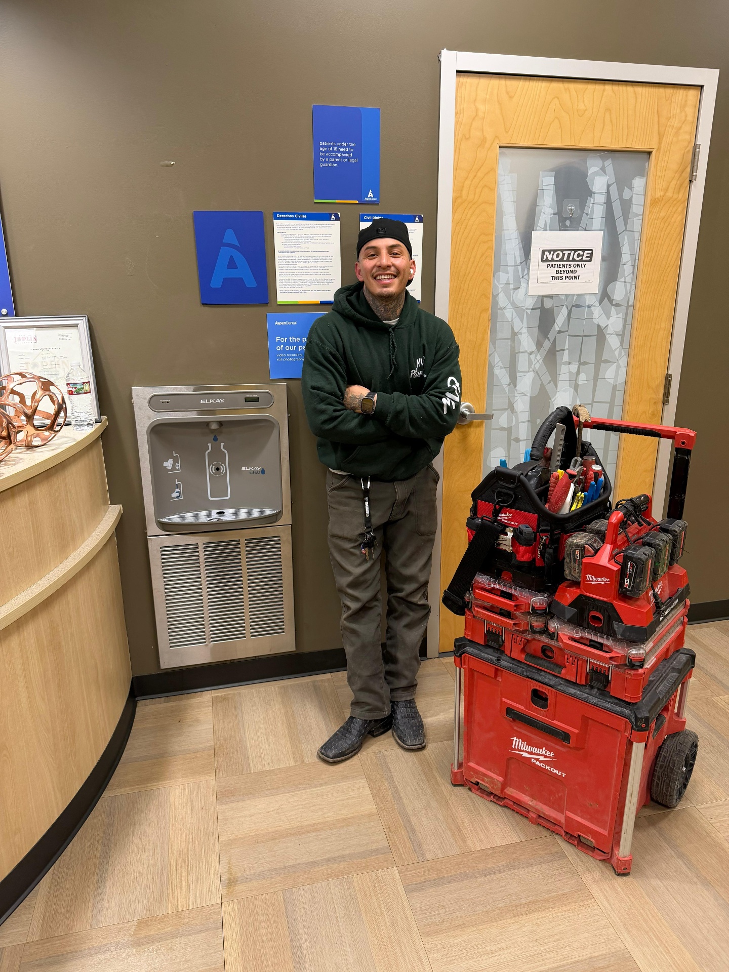 MVP Plumbing technician on a commercial service call with full Milwaukee tool kit