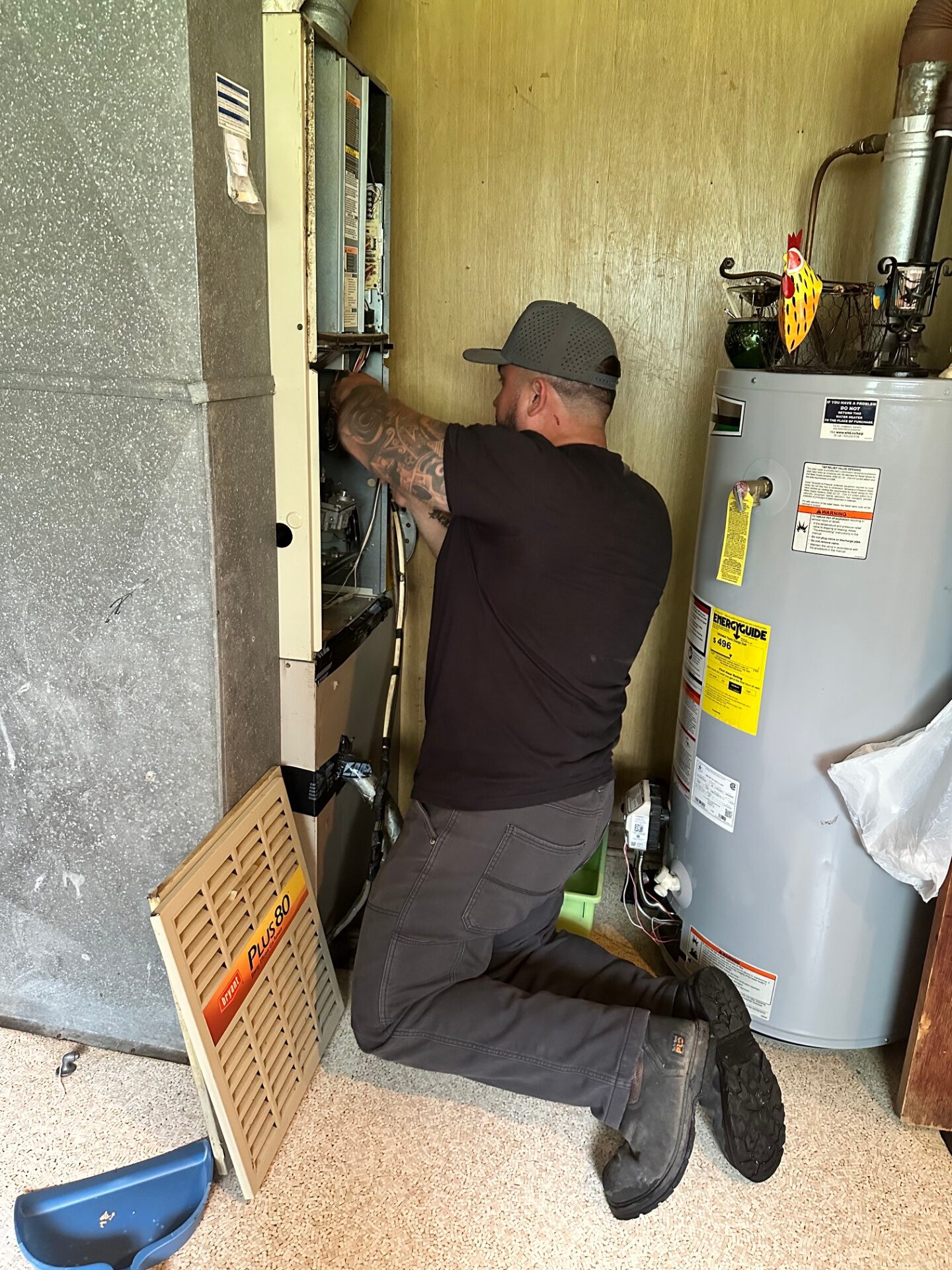 HVAC technician servicing a residential furnace and water heater